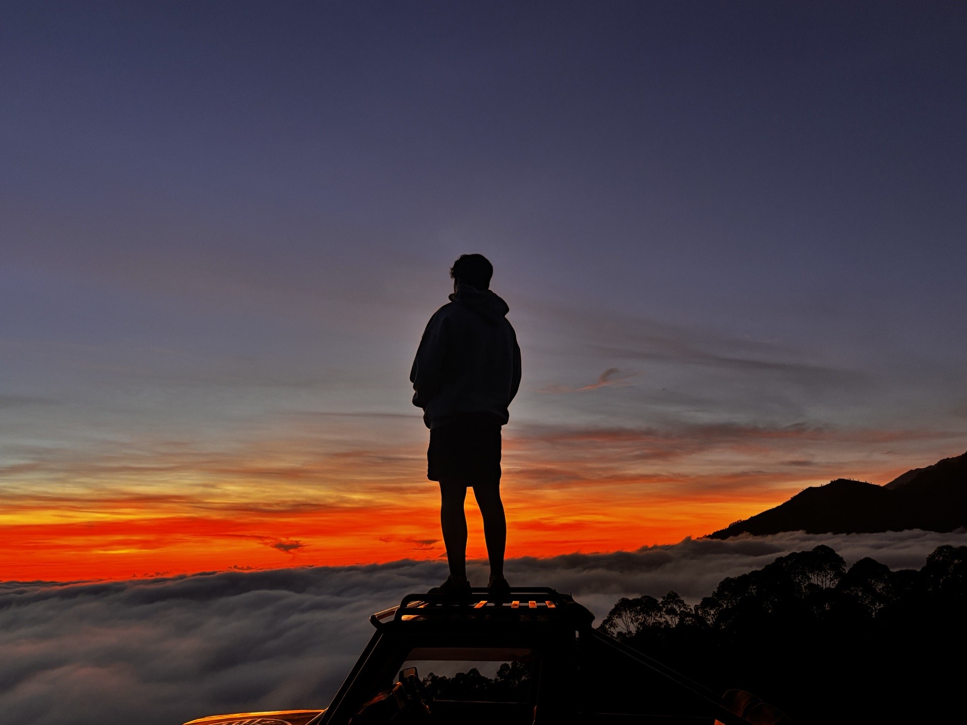 Silhouette at sunset above the clouds